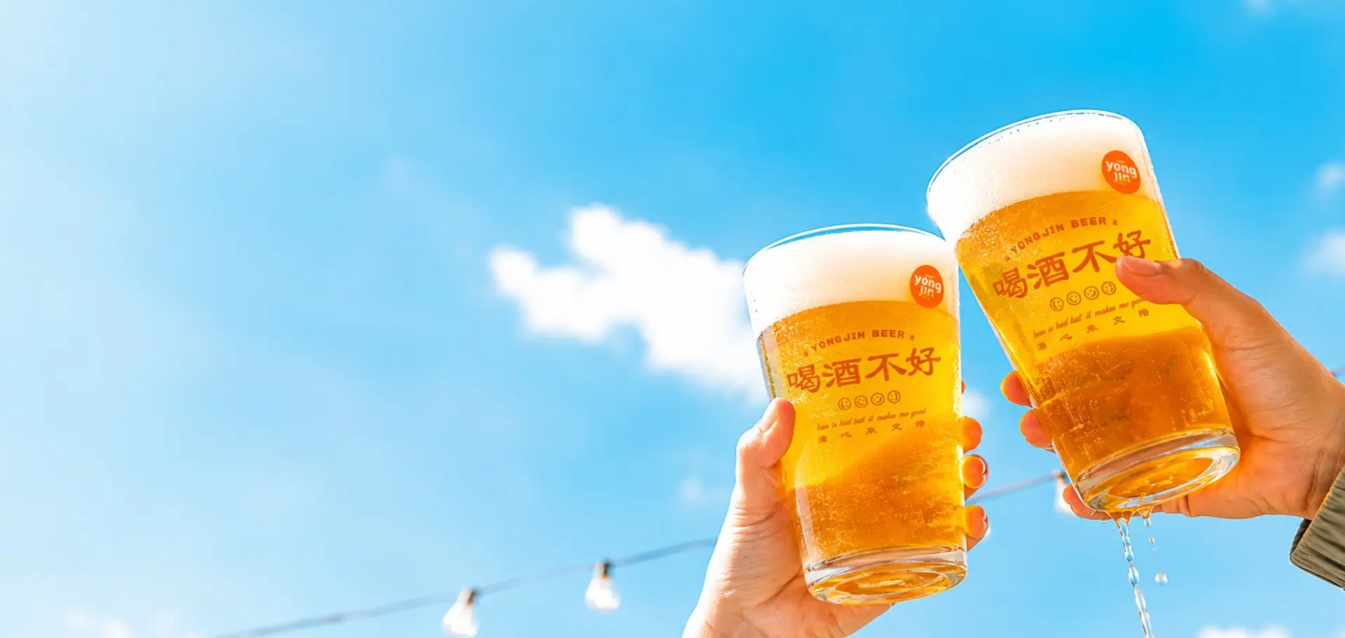 藍天下雙手高舉湧金啤酒杯乾杯