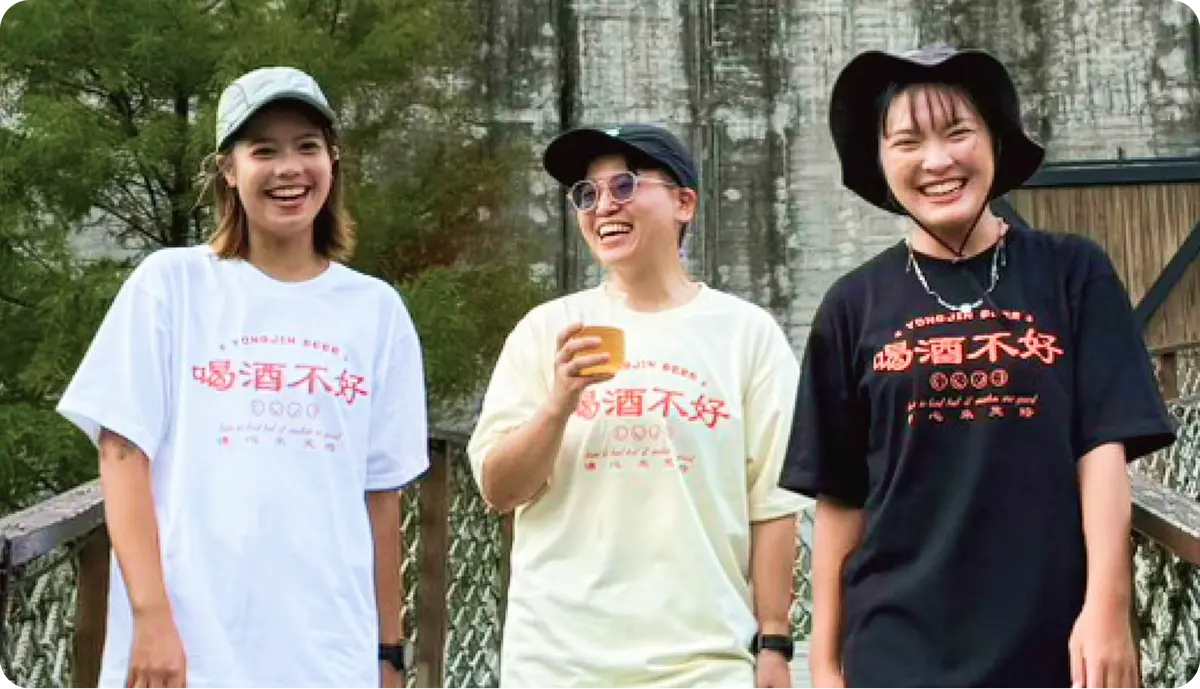 三位年輕人穿著喝酒不好品牌 T 恤